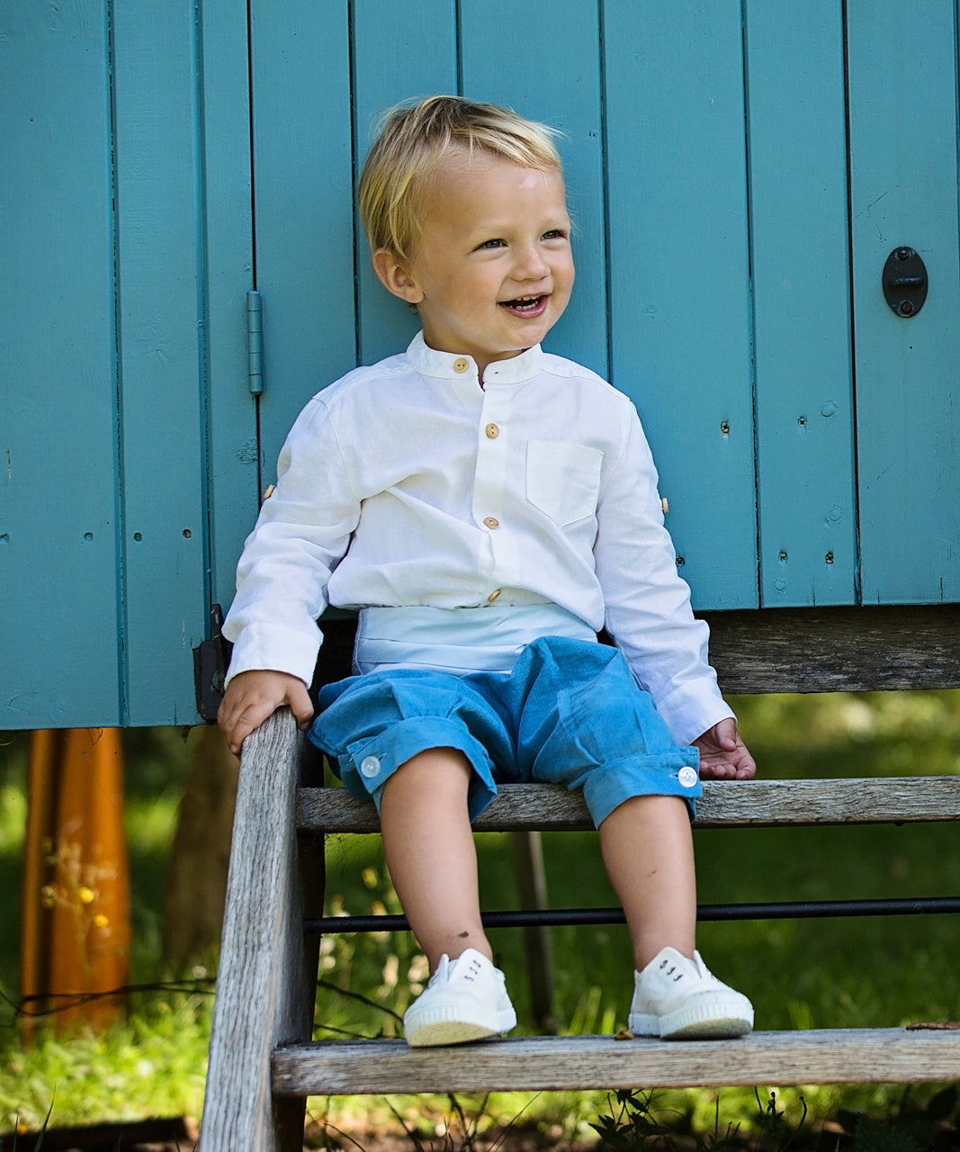 Pageboy wears linen nehru collar shirt, blue knickerbockers and duck egg blue cummerbund by Amelia Brennan Weddings