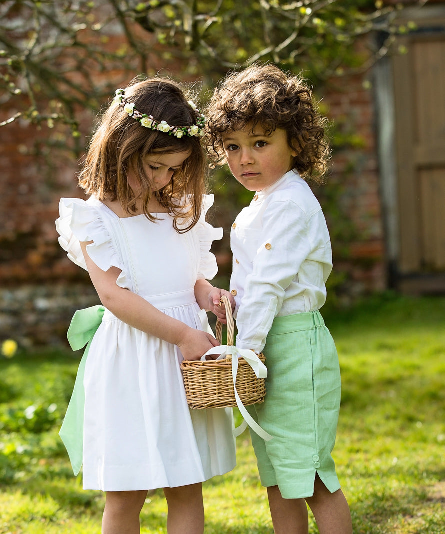 Linen Cross-Back Ruffle Flower Girl Dress with Green linen Bow and matching Pageboy outfit by Amelia Brennan