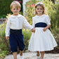 Pageboy and Bridesmaid in ivory and navy outfits by Amelia Brennan Weddings