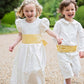 Pageboy and Bridesmaid in ivory and yellow outfits by Amelia Brennan Weddings